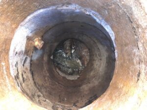 "Before" image of deteriorating manhole.